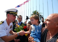 Capt. John Moore, commodore, Combined Task Force (CTF) 367, greets local residents and receives flowers shortly after the arrival of the guided-missile destroyer USS McFaul (DDG 74) to the port of Batumi. U.S. Navy photo by Mass Communication Specialist 3rd Class Eddie Harrison.