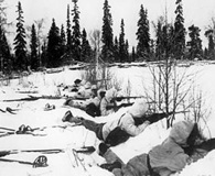 1940. Finnish ski troops take cover in the snow as they wait for advancing Soviet troops. National Archives