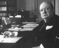 Prime Minister Sir Winston Churchill sitting behind his desk at 10 Downing Street. National Archives.