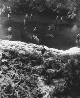 December 26, 1943: Marines hit three feet of rough water as they leave their LST to take the beach at Cape Gloucester, New Britain. (National Archives)