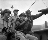Sept. 15, 1950. Brig. Gen. Courtney Whitney; Gen. Douglas MacArthur, commander in chief of U.N. Forces; and Maj. Gen. Edward M. Almond observe the shelling of Inchon from the USS Mt. McKinley. Click to enlarge. (National Archives)