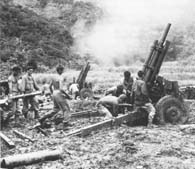 Veteran artillery men of the 122d Field Artillery fire a 105 mm howitzer during the Battle of Balete Pass. (MacArthur Memorial)