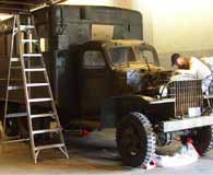 A museum technician works to restore Patton’s WWII command van.