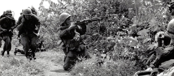 Pfc T.J. Manning (left), radio operator and his platoon commander, 2nd Lt. move into action during a fire-fight on Operation Beacon Hill. Marines are from D, 1/4. National Archives.