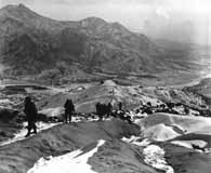 January 1951. Men of the 19th Infantry Regiment work their way over  snowy mountains attempting to locate enemy lines and positions during the Korean War. (National Archives)