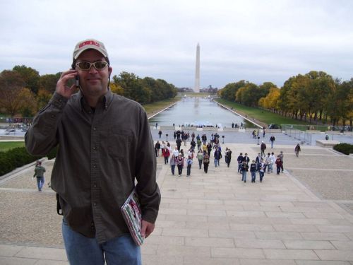 Action Shot, on the phone calling home - at the Lincoln Memorial looking back over the reflecting pool at the Washington Monument.  Washington D.C.