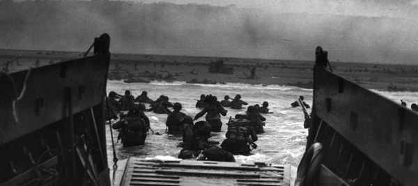 June 6, 1944. Troops of the 16th Infantry Regiment land at the Easy Red sector of Omaha Beach during the D-Day invasion. National Archives.
