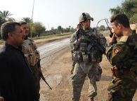 November 2, 2008. An Iraqi soldier radios in information on an Iraqi civilian (left) while Army Staff Sgt. Justin Wrightman of the 1st Stryker Brigade Combat Team, 25th Infantry Division, watches. The 1-25 SBCT is partnering with the Iraqi army to clear the Diyala River Valley and disrupt al-Qaida networks and weapons caches in and around the DRV. Photo by Spc. Bobby Allen
