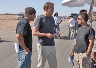 SSgt Eric Kocher (left) and author Evan Wright (center) with actor Jeffrey John Carisalez on location. Photo by Paul Schiraldi/HBO.