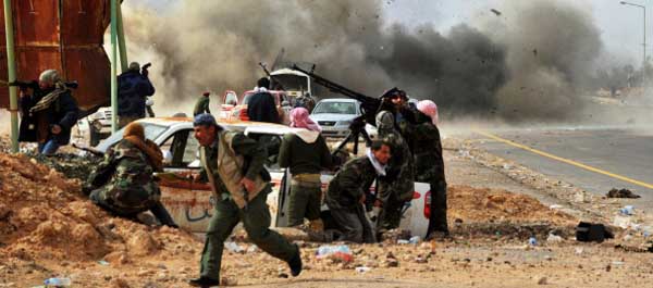 March 10, 2011. Shrapnel flies through the air as a tank shell explodes near Libyan rebel fighters defending their last position against Muammar Qaddafi's loyalist forces at the north-central key Libyan oil town of Ras Lanuf. (Roberto Schmidt/AFP/Getty Images)