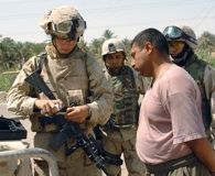US Army Spc-4 Harris, 2nd Battalion, 70th Armored Regiment (2/70), 1st Armored Division, Fort Riley, Kansas, uses an explosive ordnance detection kit on Iraqis suspected of making explosive devices in Mamadia, Iraq. Photo by Spc. Ronald Shaw Jr. Click to enlarge.