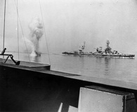 A German heavy artillery shell lands between USS Texas (background) and USS Arkansas off Cherbourg. Click to enlarge. National Archives.